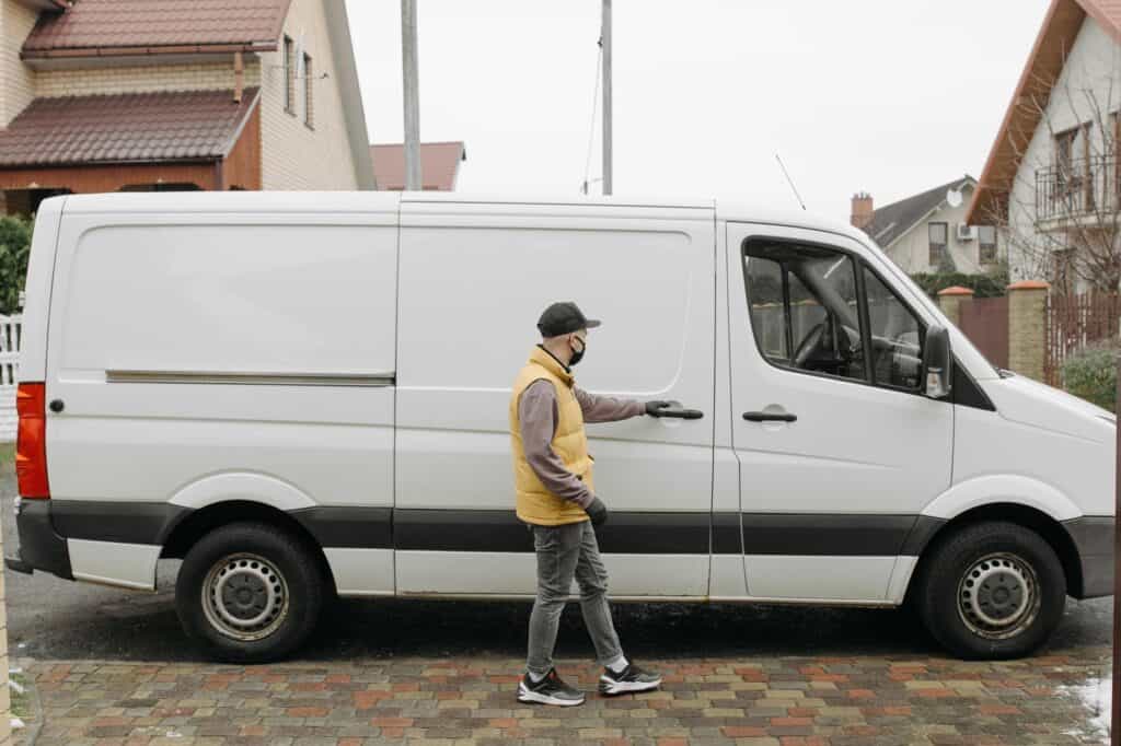 A mover and a van outside the house in the concept of moving to Enfield