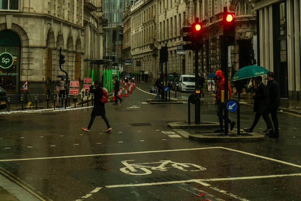 Pedestrian walking on the street on a rainy day in the concept of services and amenities in Enfield.